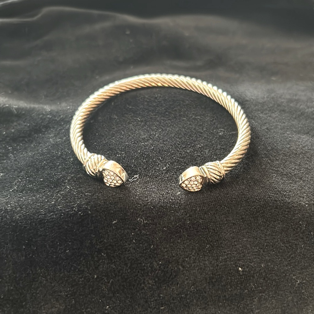 Silver tone twisted look slip on bangle with silver tone hearts at opening